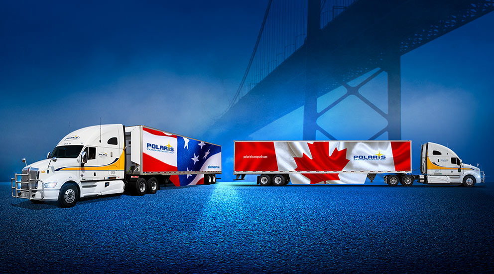 One Polaris truck with U.S. flag on trailer and another with Canada flag on trailer