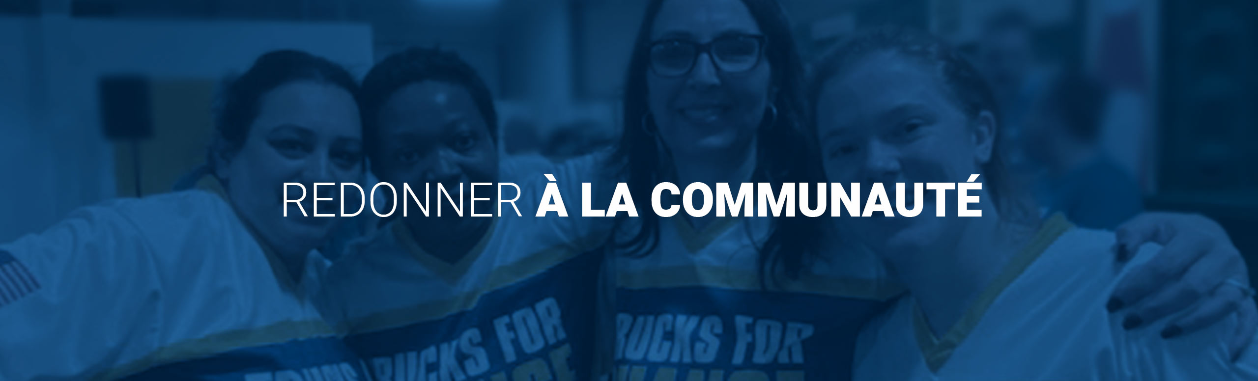 Mots « Redonner à la communauté » avec quatre femmes portant des maillots « Trucks for Change » en arrière-plan