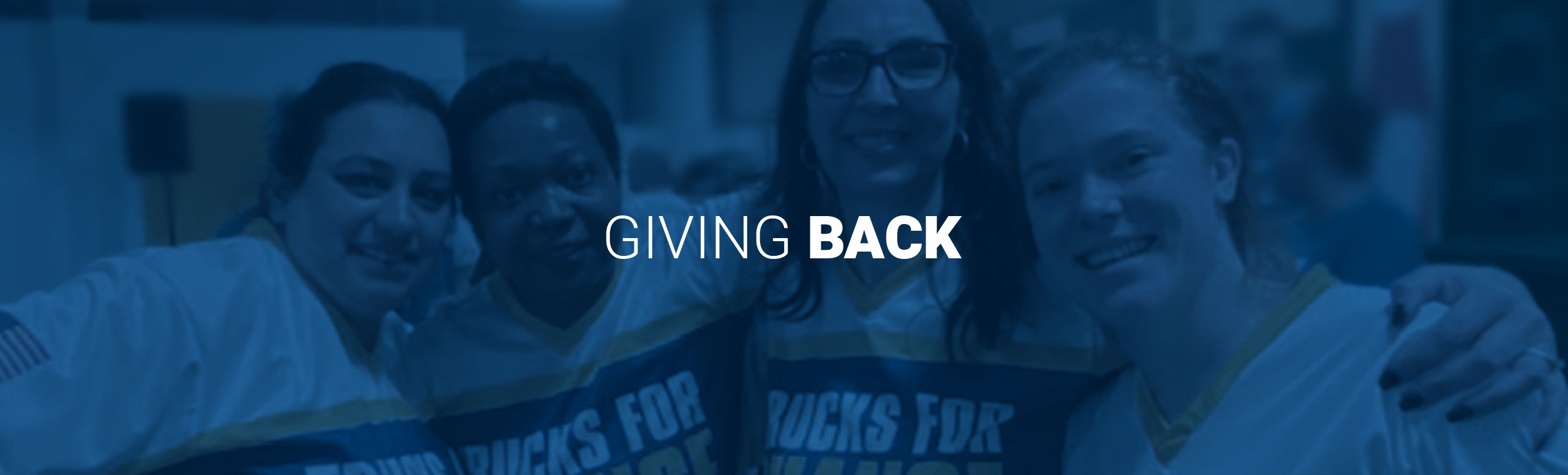 Giving Back words with four women wearing Trucks for Change jerseys in background 