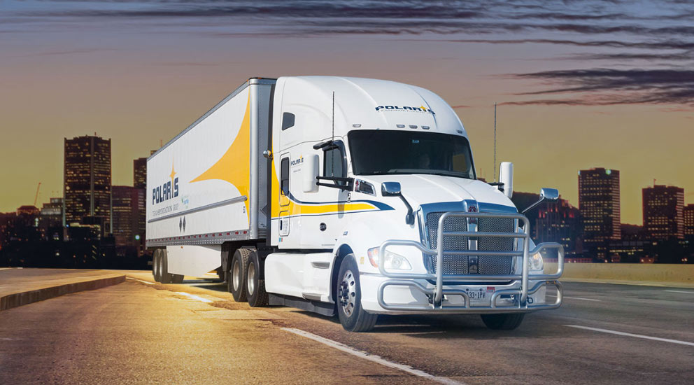Polaris semi-trailer driving on freeway with cityscape in background 