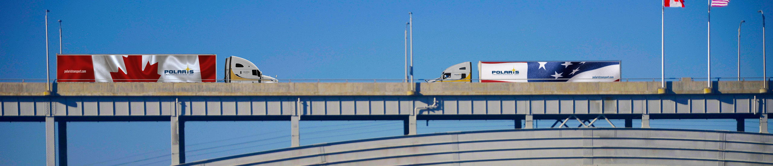 One Polaris truck with Canadian trailer driving toward another Polaris truck with U.S. trailer on bridge 