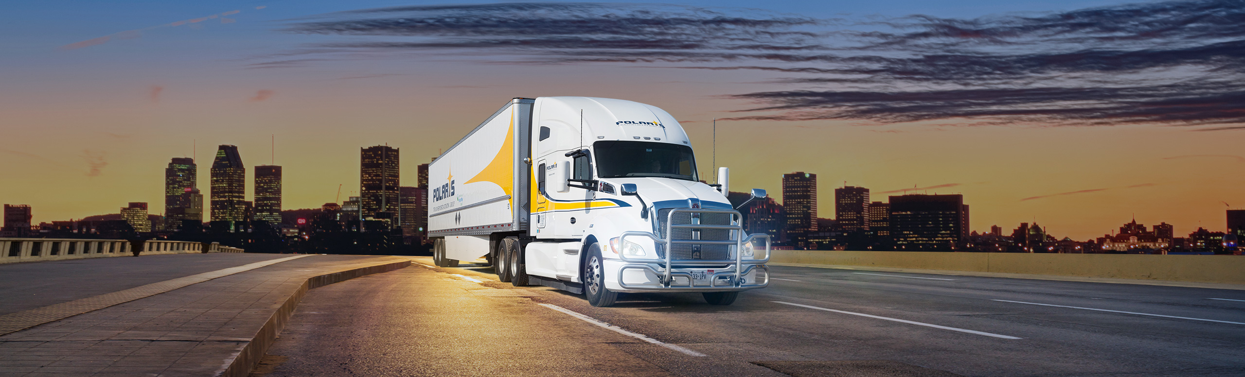 Polaris semi-trailer driving on freeway with cityscape in background